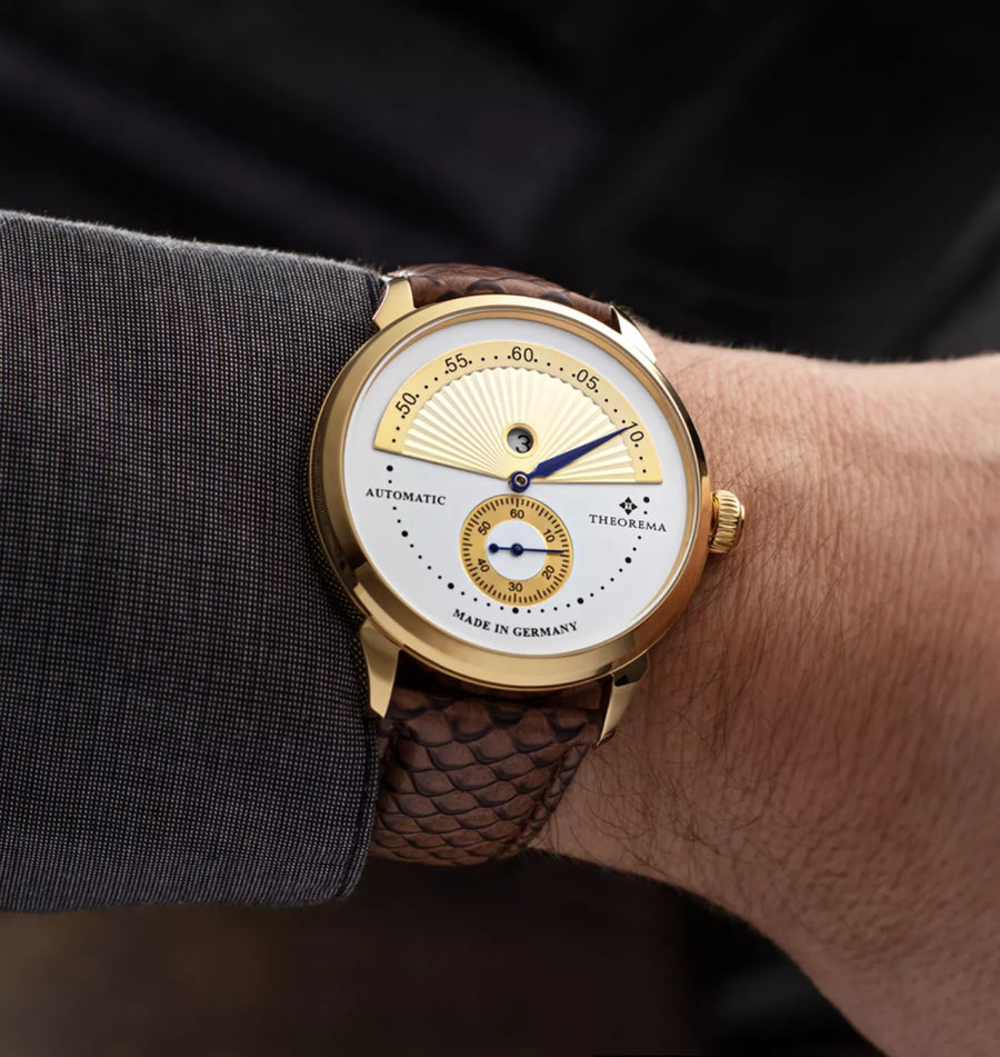 Fish pattern design leather band on a gold case color and multi tone dial.